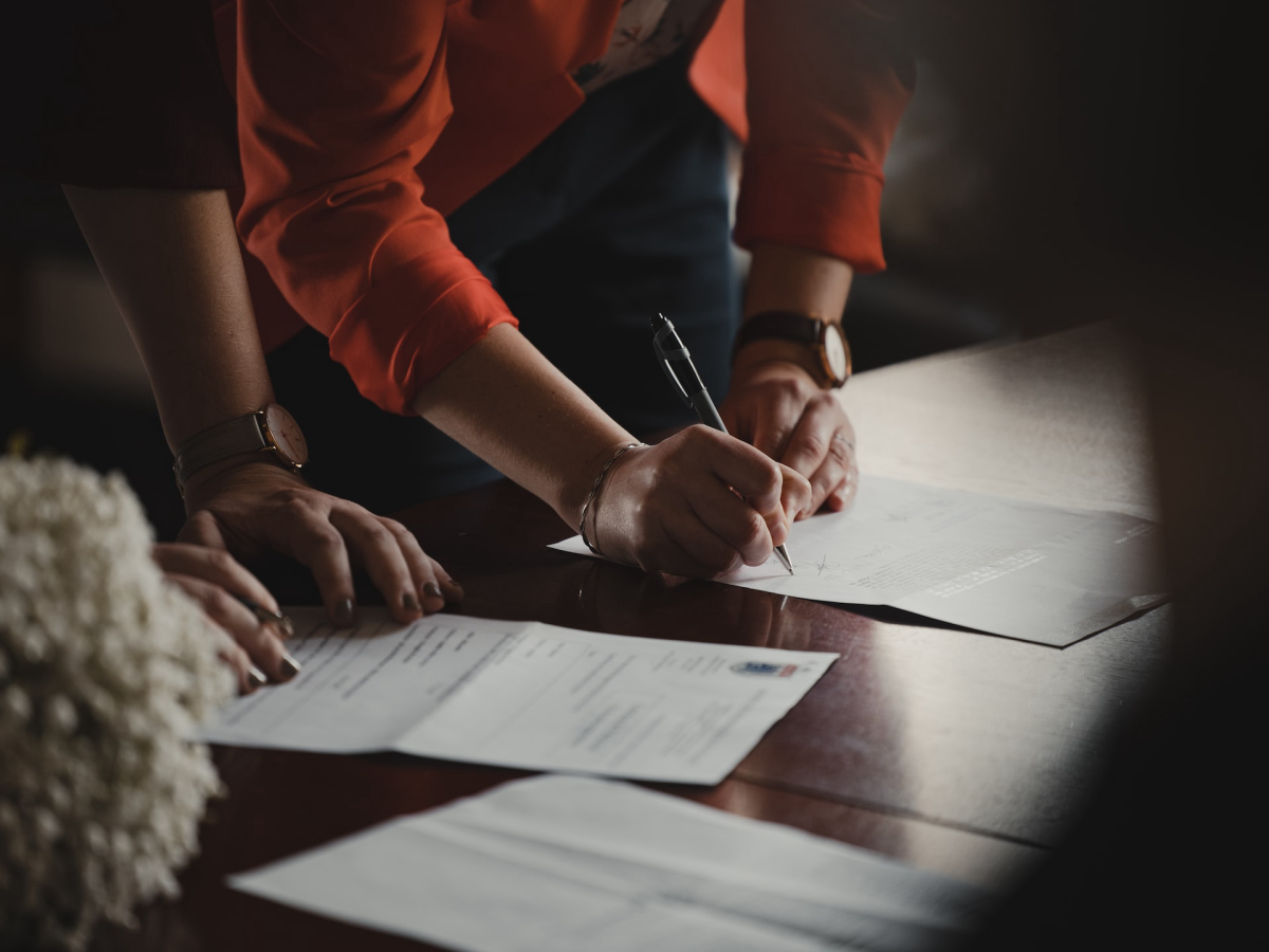 Image of a picture of a woman signing documents